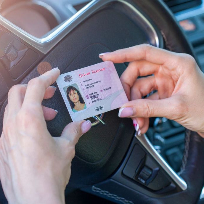 Acquire drivers license in Bangkok, Thailand. Person holding a driver's license in front of a car steering wheel, Thailand, Bangkok
